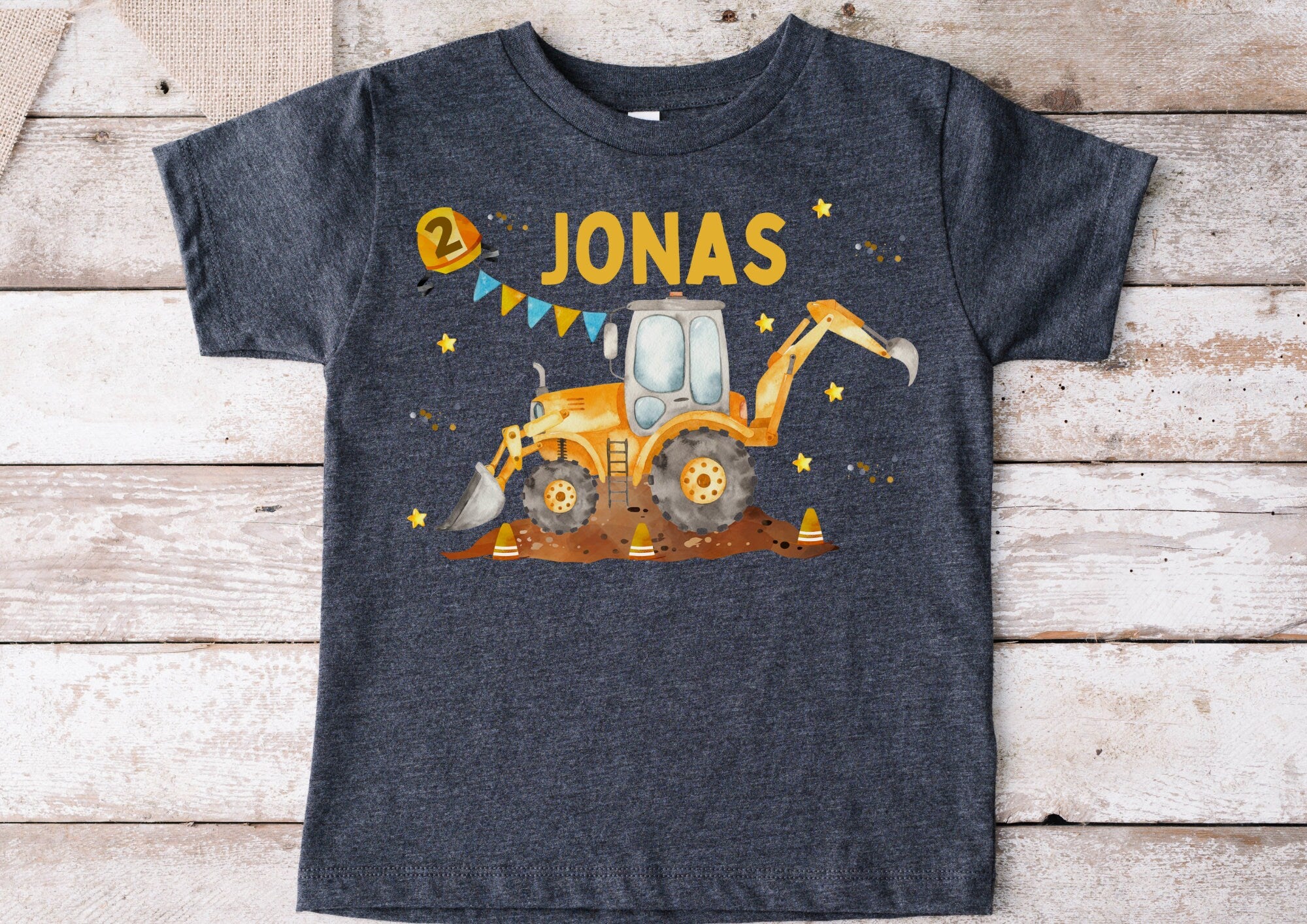 Bügelbild mit Bagger und Bauarbeiter zum Geburtstag – personalisiert mit Name und Alter – Motiv auf dunklem Kinder-Shirt abgebildet